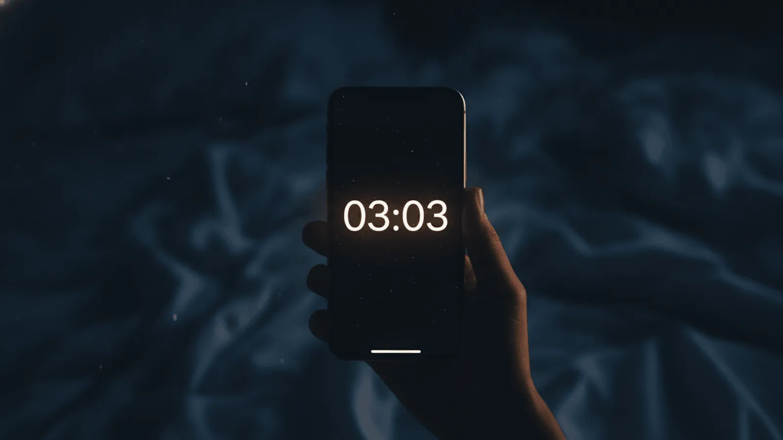 Relógio digital de cabeceira marcando 03:03 em números suaves, num quarto tranquilo banhado por uma luz dourada e serena de madrugada